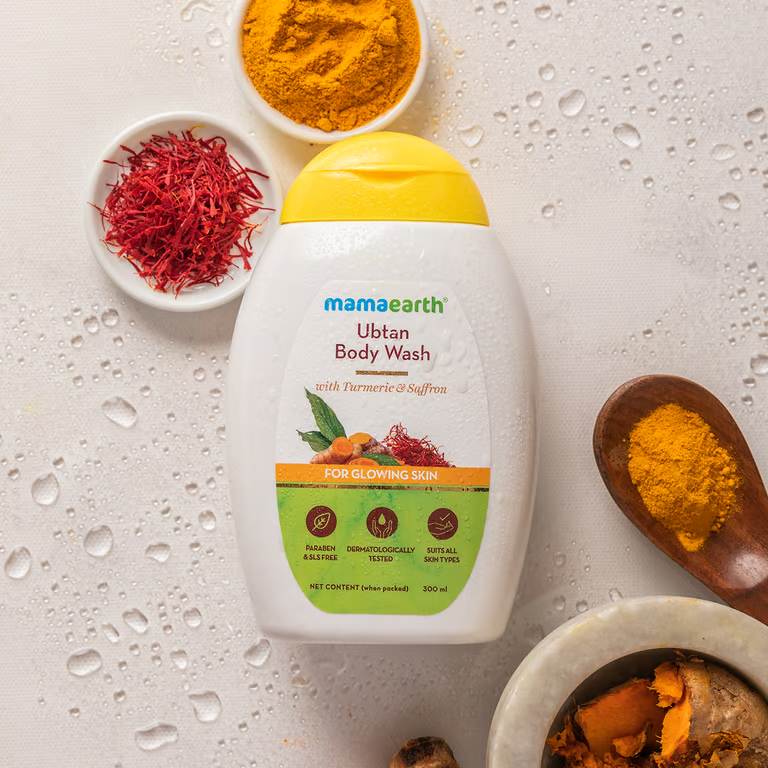 Mamaearth ubtan body wash with turmeric powder and saffron background